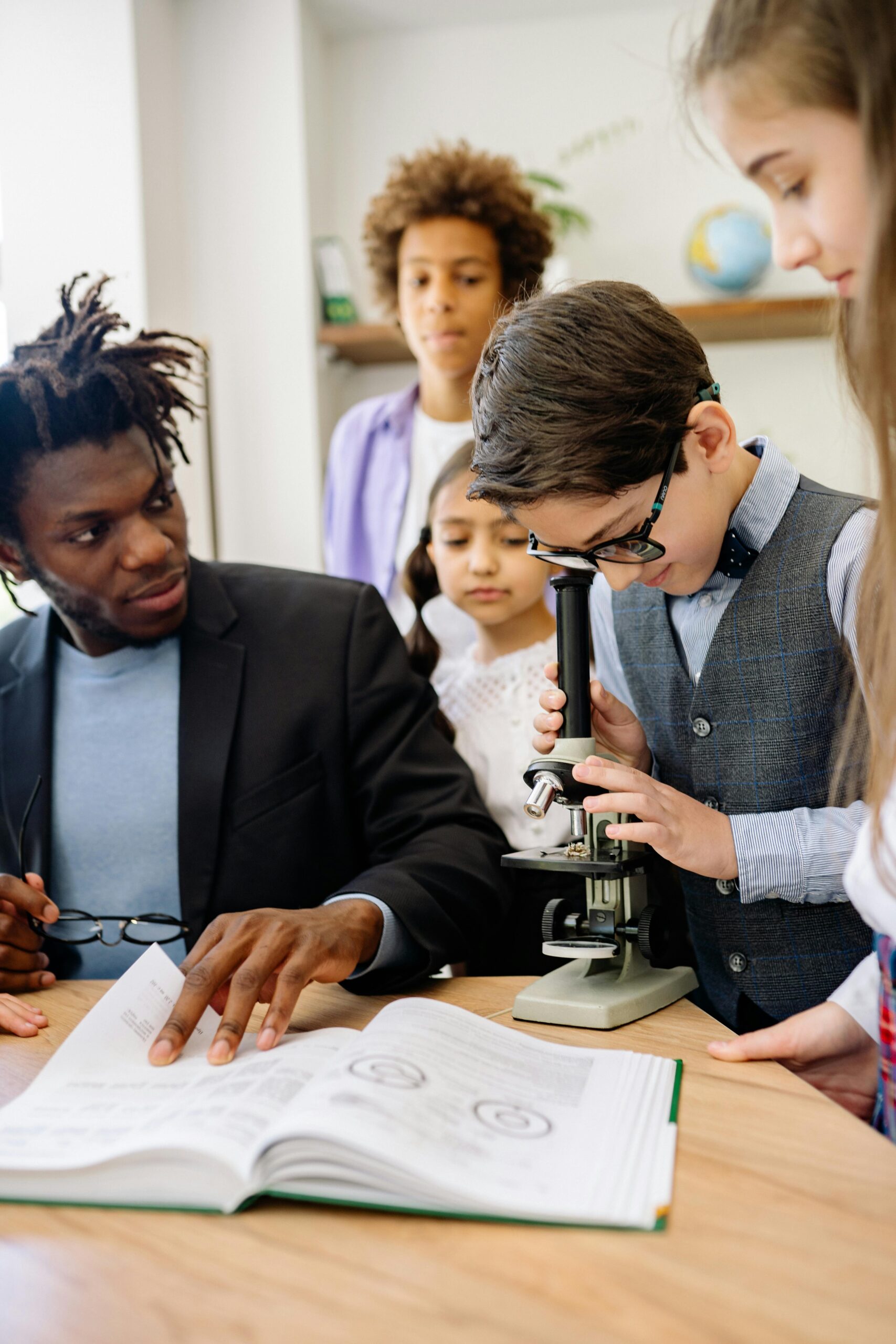 science with black tutor and kids and microscope