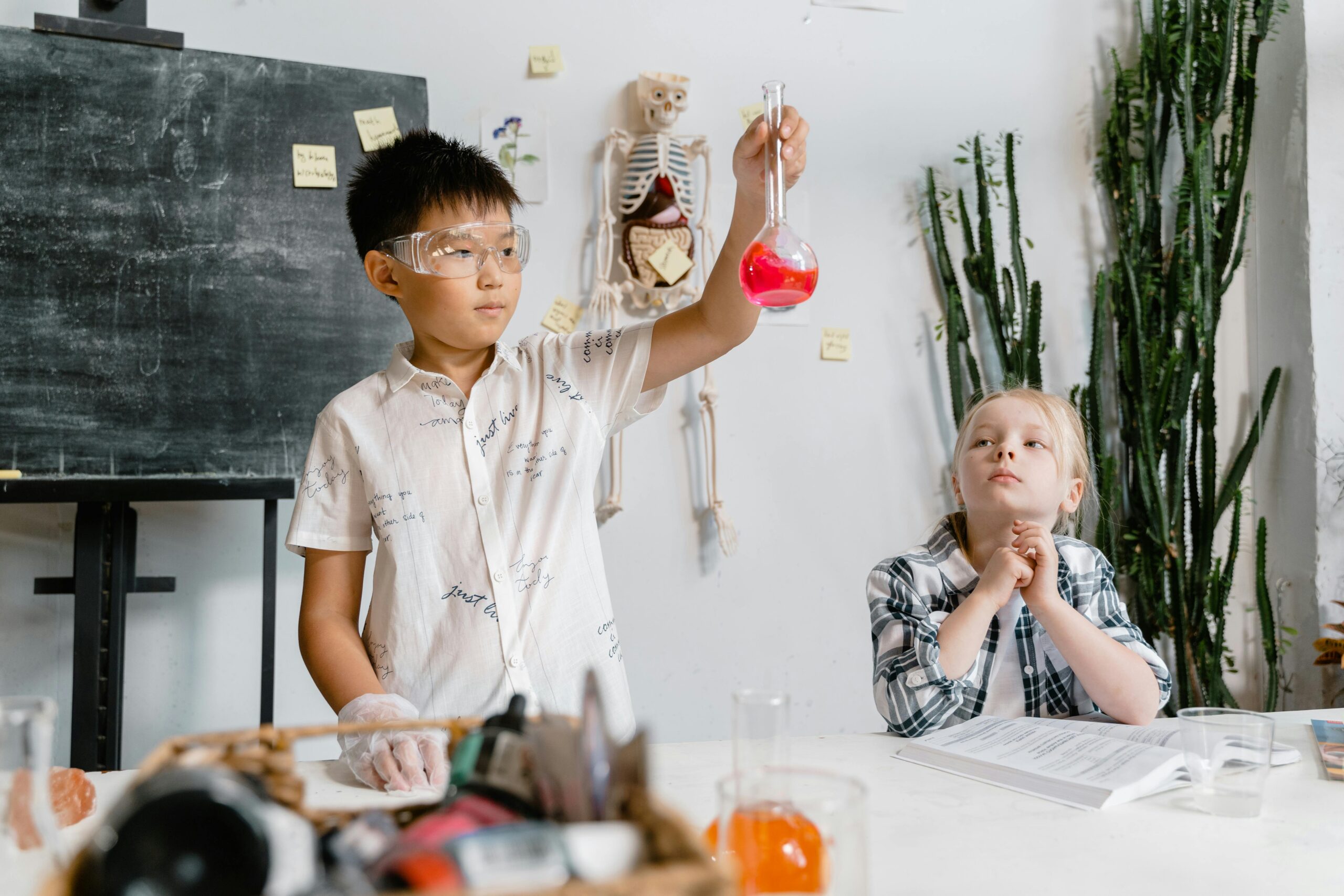 science with two kids holding tube with pink liquid